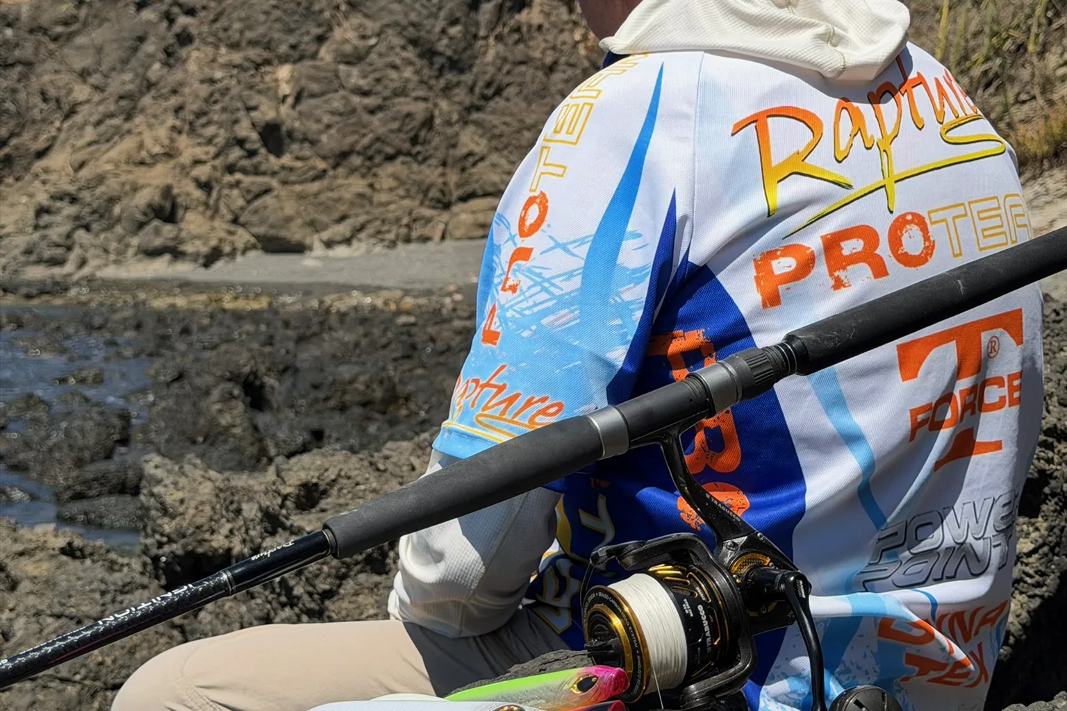 Pescatore con canna da spinning sulla scogliera